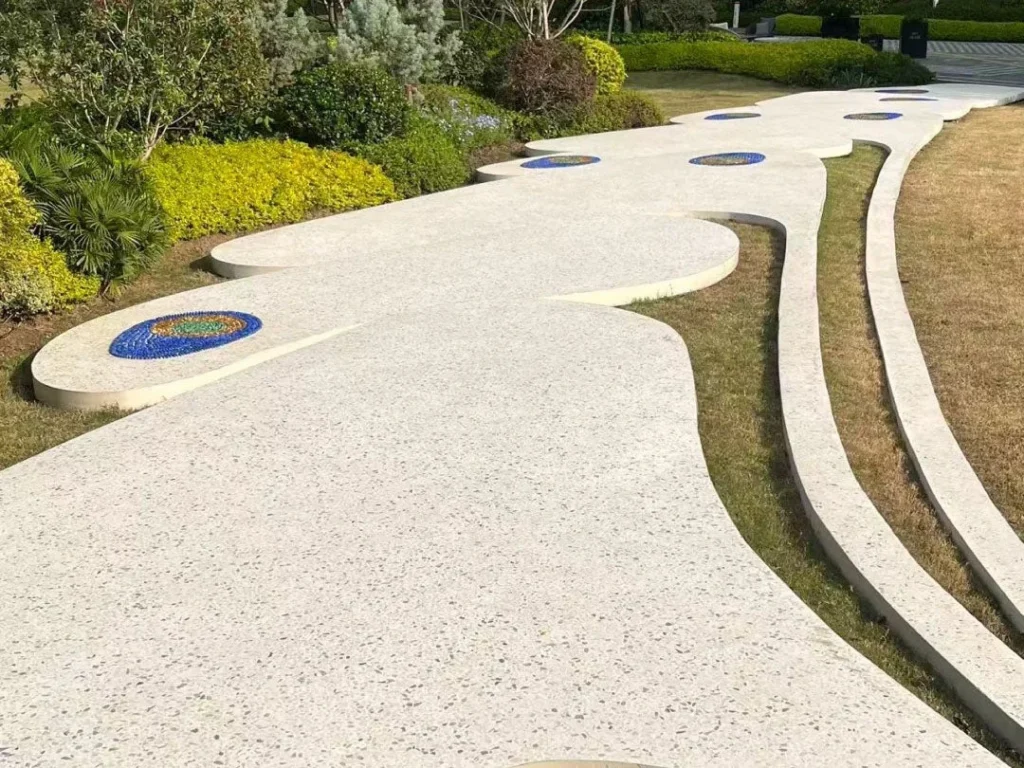 Terrazzo cementizio personalizzato per pavimento esterno giardino, percorso curvo con finitura levigata e inserti decorativi